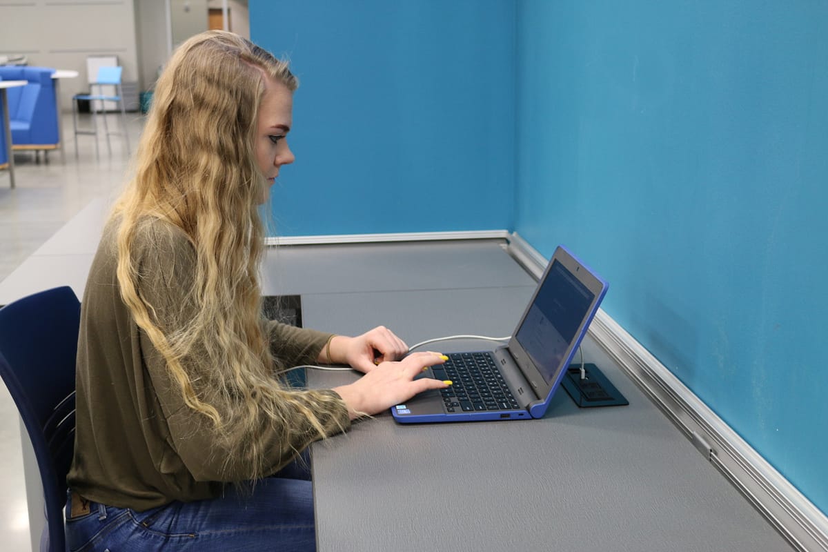 Student working on blue laptop